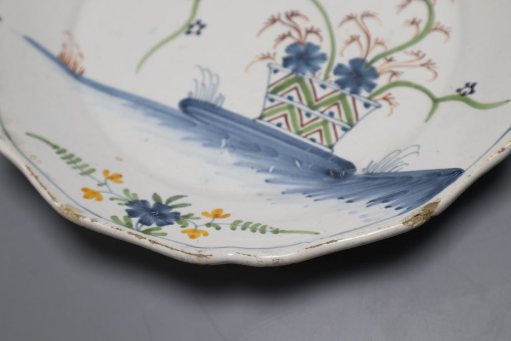 An 18th century faience dish, painted in polychrome enamels, 23cm